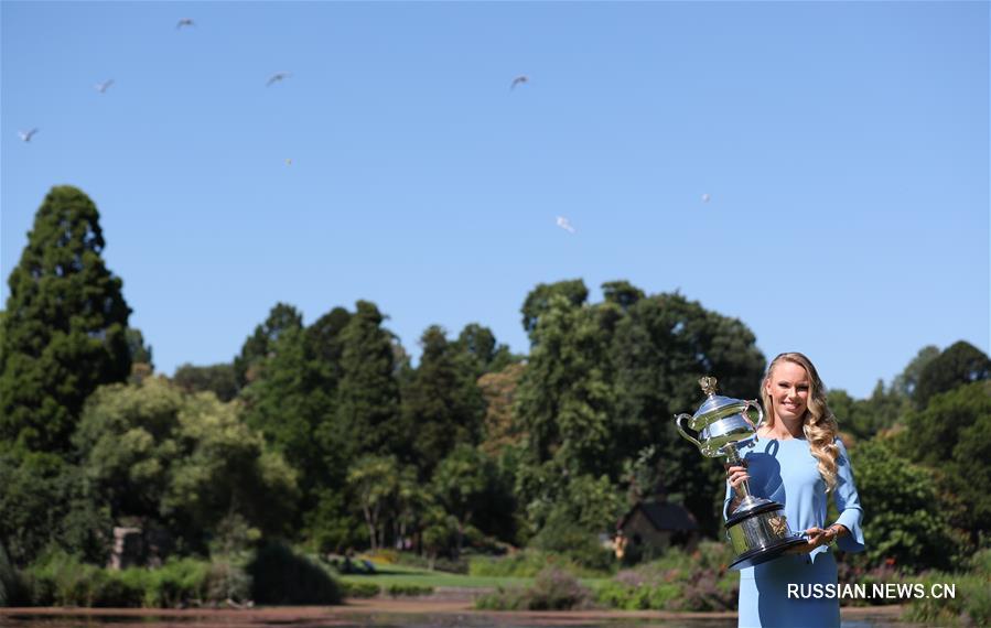 Возняцки демонстрирует выигранный ею кубок Открытого чемпионата Австралии по теннису