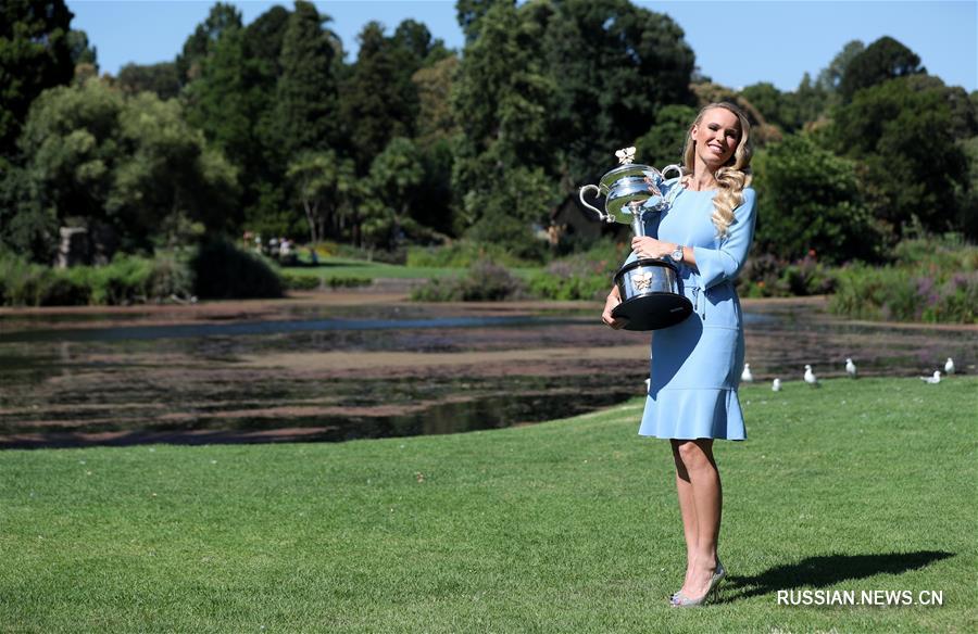 Возняцки демонстрирует выигранный ею кубок Открытого чемпионата Австралии по теннису