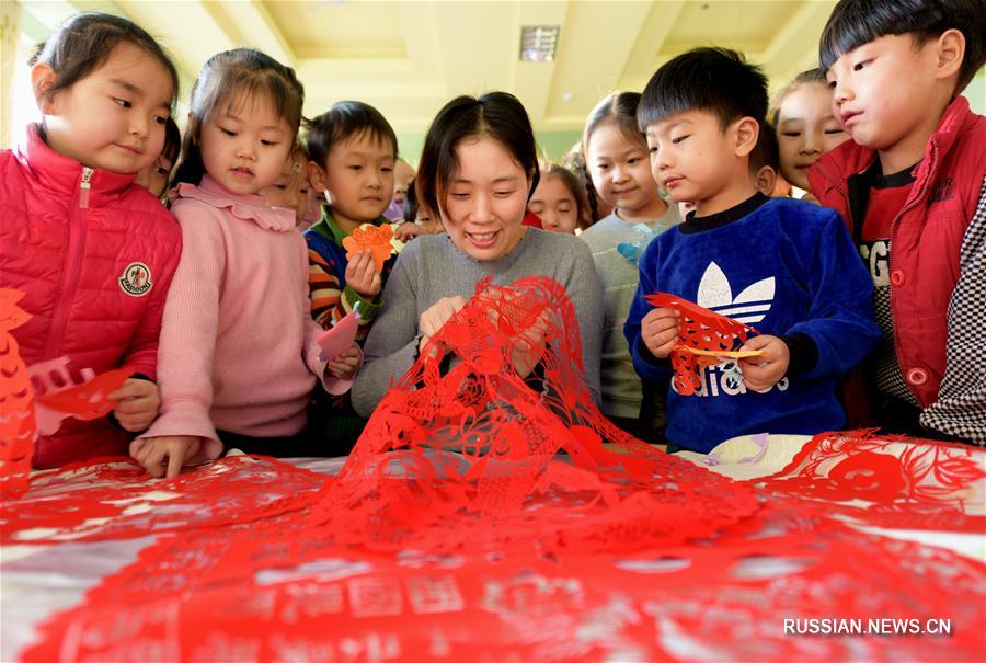 В одном из детских садов Хэншуя учатся вырезать новогодних бумажных собачек