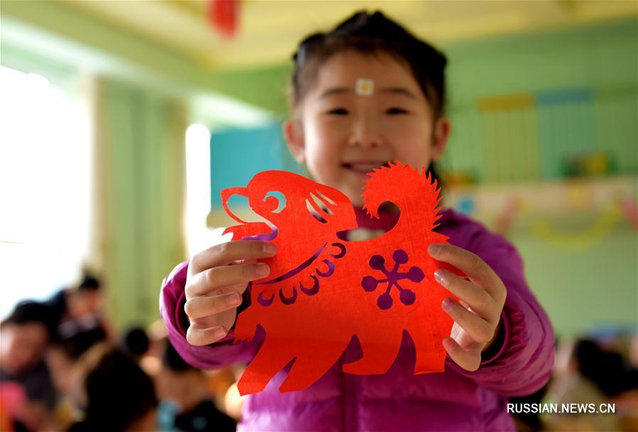 В одном из детских садов Хэншуя учатся вырезать новогодних бумажных собачек