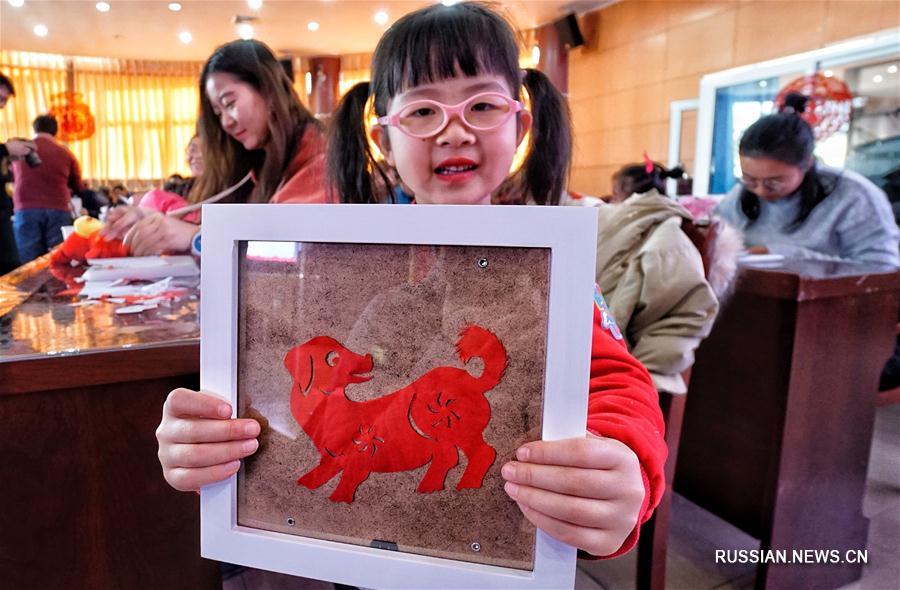 Жители поселка Чансиньдянь учатся вырезать из бумаги и готовить новогодние блины