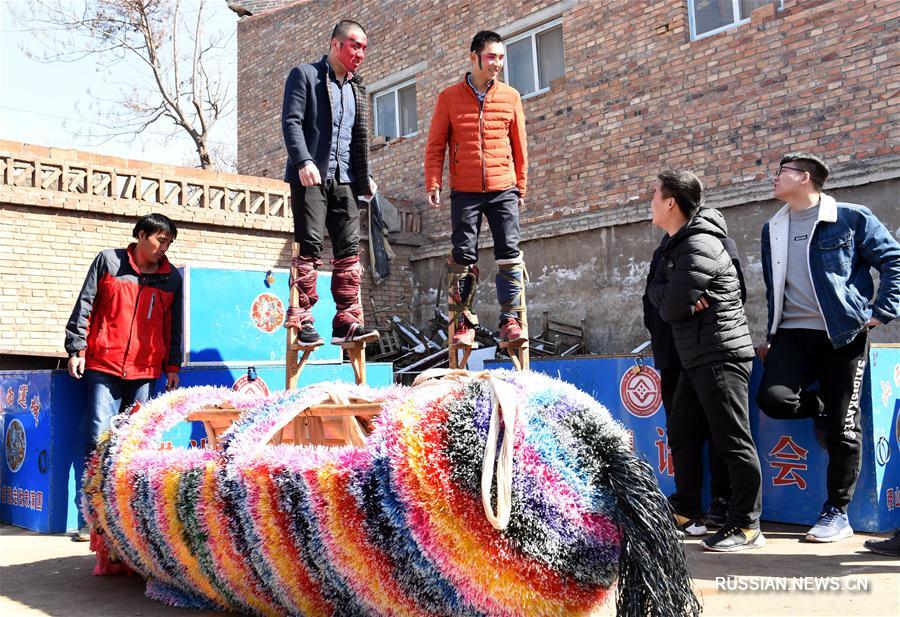 Праздничное шествие на ходулях в костюмах зверей в поселке Цинхэ 