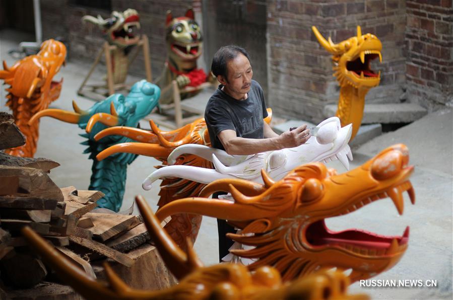 Резчик по дереву Чэнь Биншоу изготавливает скульптуры на нос даосяньских лодок-драконов