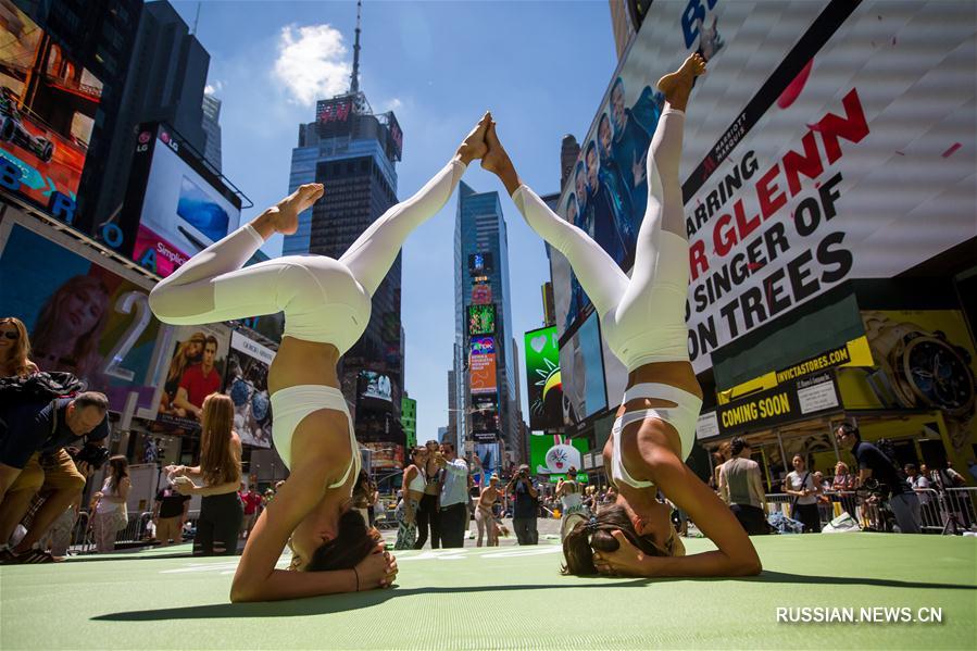 Тысячи любителей йоги отметили летнее солнцестояние бесплатным уроком на Таймс-сквер  в Нью-Йорке