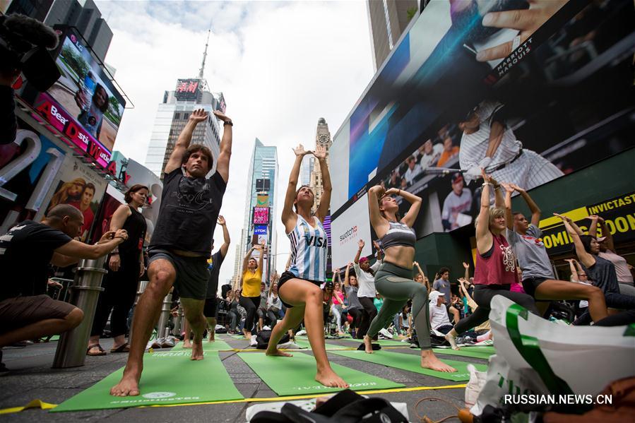 Тысячи любителей йоги отметили летнее солнцестояние бесплатным уроком на Таймс-сквер  в Нью-Йорке
