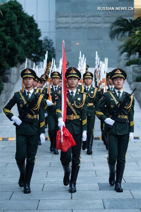Церемония поднятия госфлага КНР в лагере контингента НОАК по случаю 19-летия восстановления суверенитета Китая над Аомэнем 
