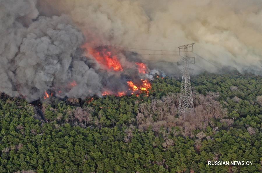 На северо-востоке Китая пожарные борются с горным пожаром