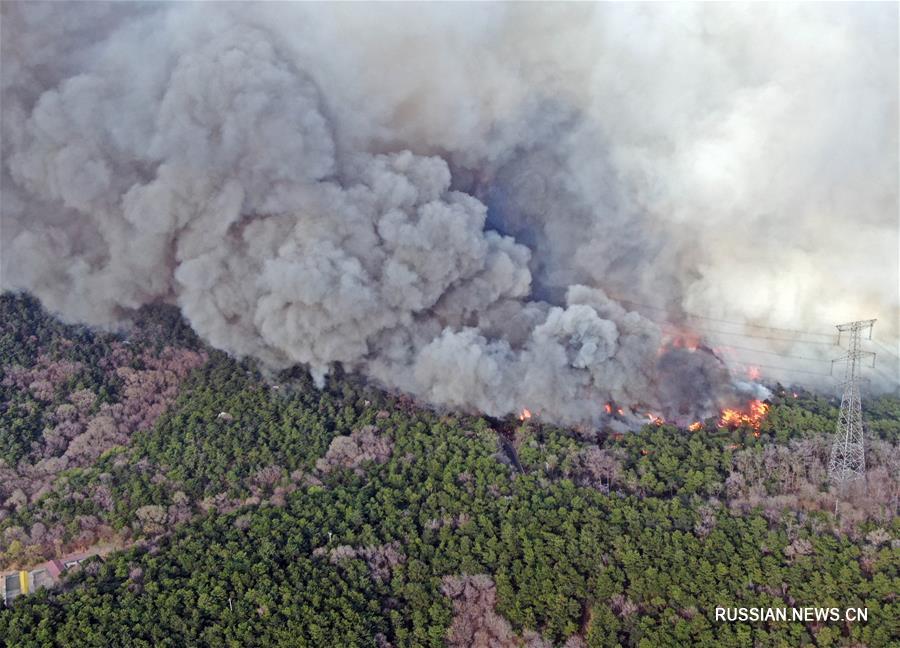 На северо-востоке Китая пожарные борются с горным пожаром