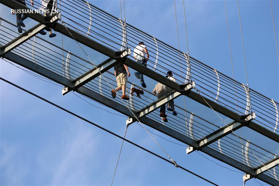 Туристы гуляли по стеклянному мосту на большой высоте в городе Цзянъинь