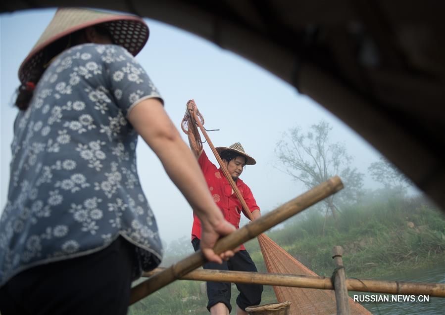 Супруги-рыбаки позируют перед объективами фотокамер в провинции Чжэцзян