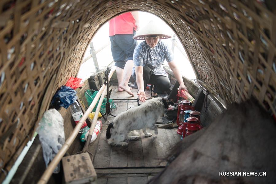 Супруги-рыбаки позируют перед объективами фотокамер в провинции Чжэцзян
