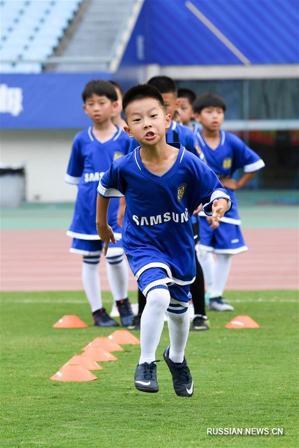 В летние каникулы китайские школьники наслаждаются футбольным спортом