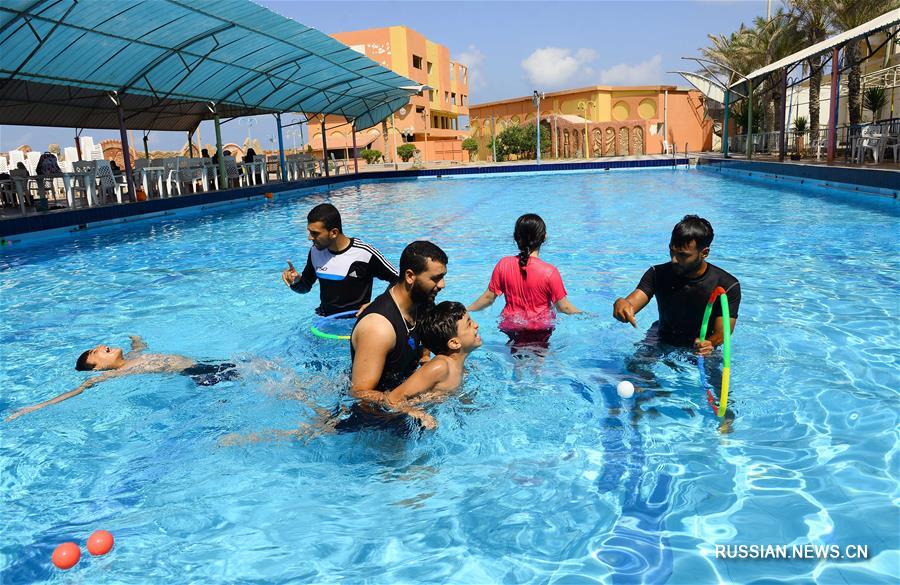 Тренеры по плаванию играют с детьми-аутистами в секторе Газа