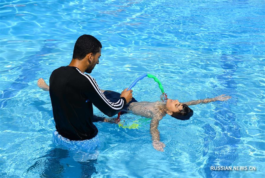 Тренеры по плаванию играют с детьми-аутистами в секторе Газа