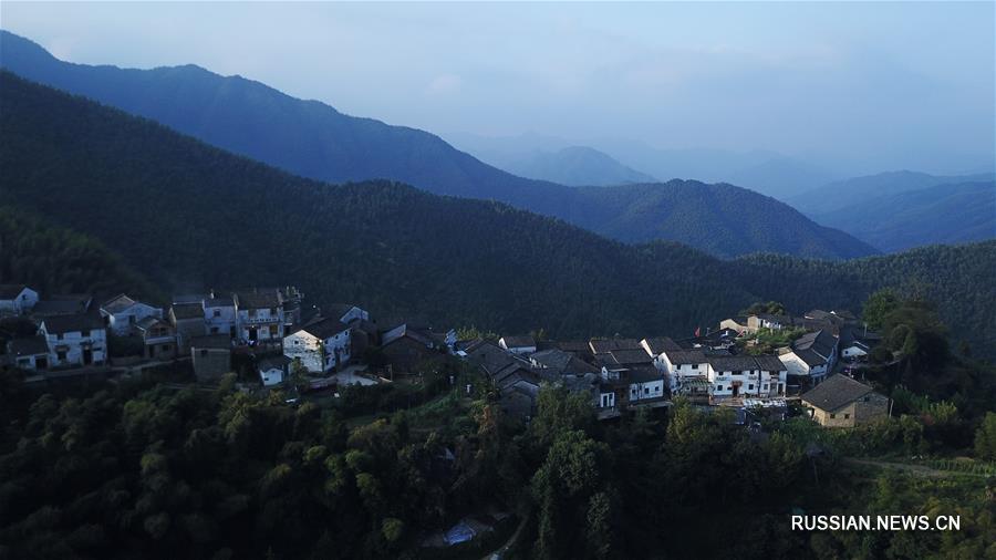 Первые лучи солнца над горной деревушкой в провинции Аньхой 