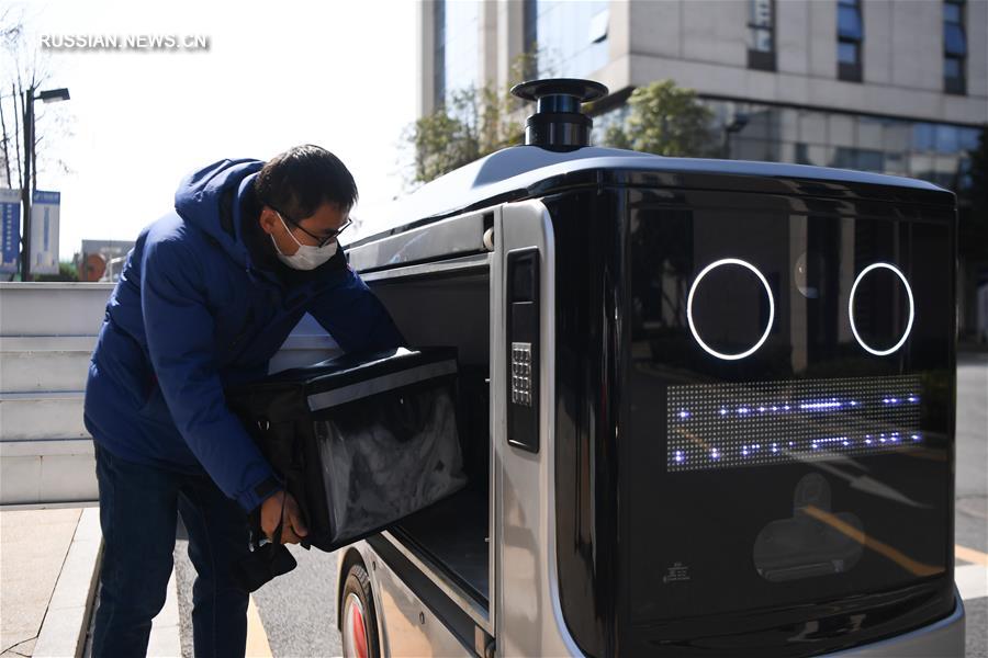 Борьба со вспышкой коронавирусной инфекции -- Роботы доставляют обеды работникам предприятий в Чанша