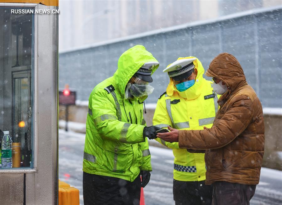 Сотрудники дорожной полиции г. Ухань несут службу на посту в снег