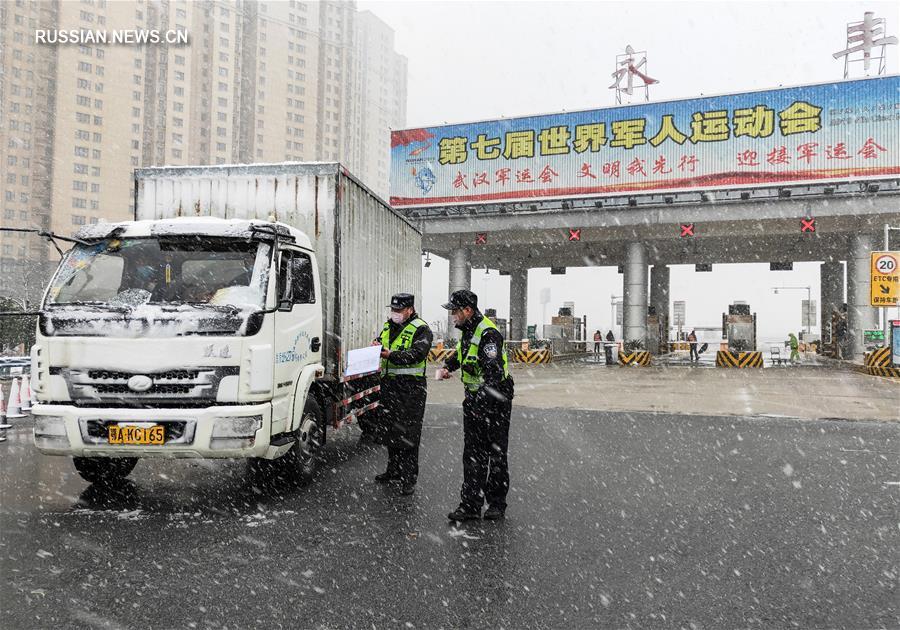 Сотрудники дорожной полиции г. Ухань несут службу на посту в снег