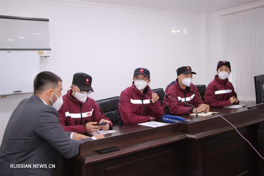 Молодой узбекский переводчик помогает группе медицинских экспертов из Китая