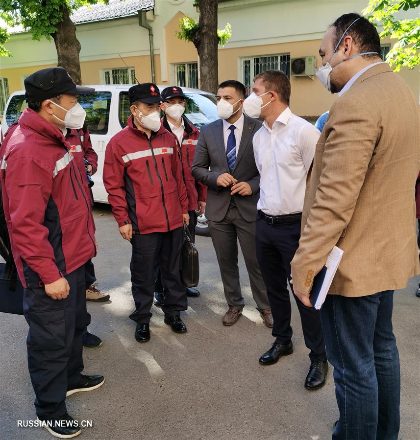 Молодой узбекский переводчик помогает группе медицинских экспертов из Китая