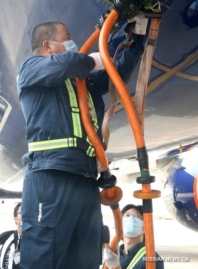 Сотрудники шанхайского аэропорта Пудун добросовестно исполняют служебные обязанности в условиях высокой температуры воздуха