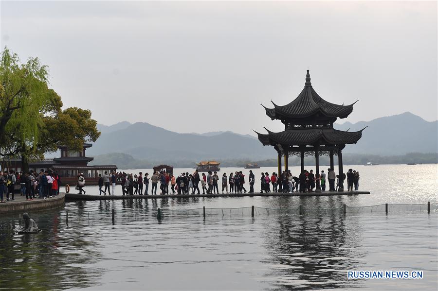 Праздничный наплыв посетителей в ландшафтном парке Сиху в Ханчжоу