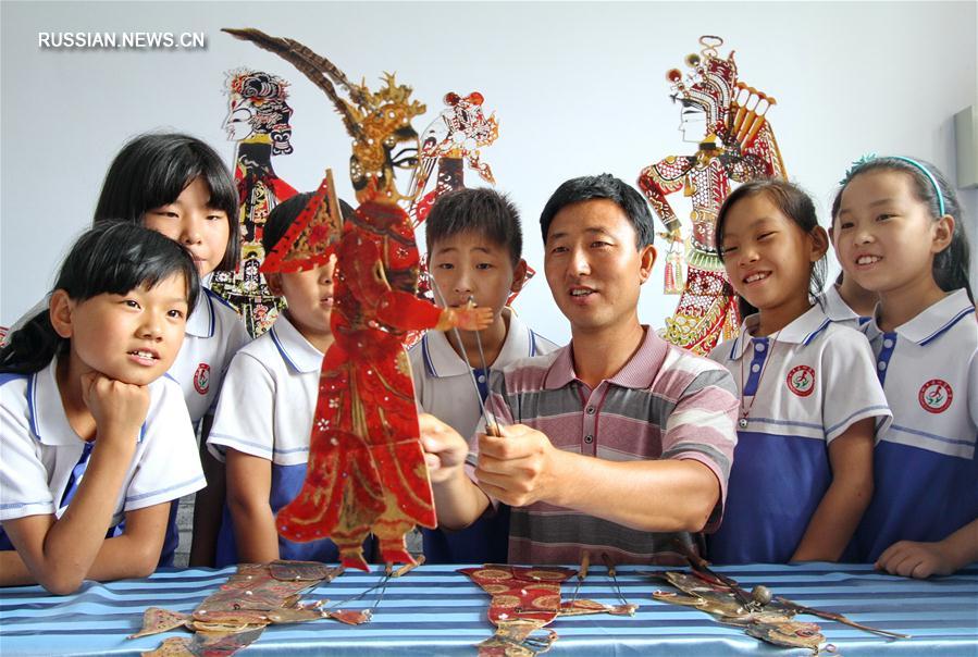 В одной из начальных школ Ханьданя для "оставленных" детей организованы бесплатные уроки по искусству театра теней
