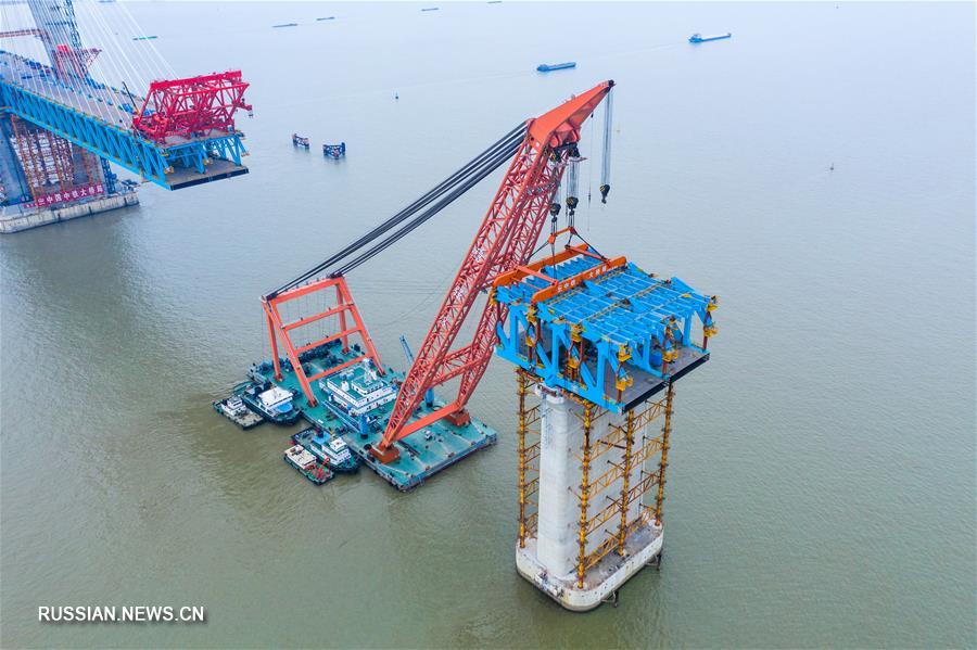 Строители установили последнюю стальную балку на опоры главной фарватерной секции моста Хутун