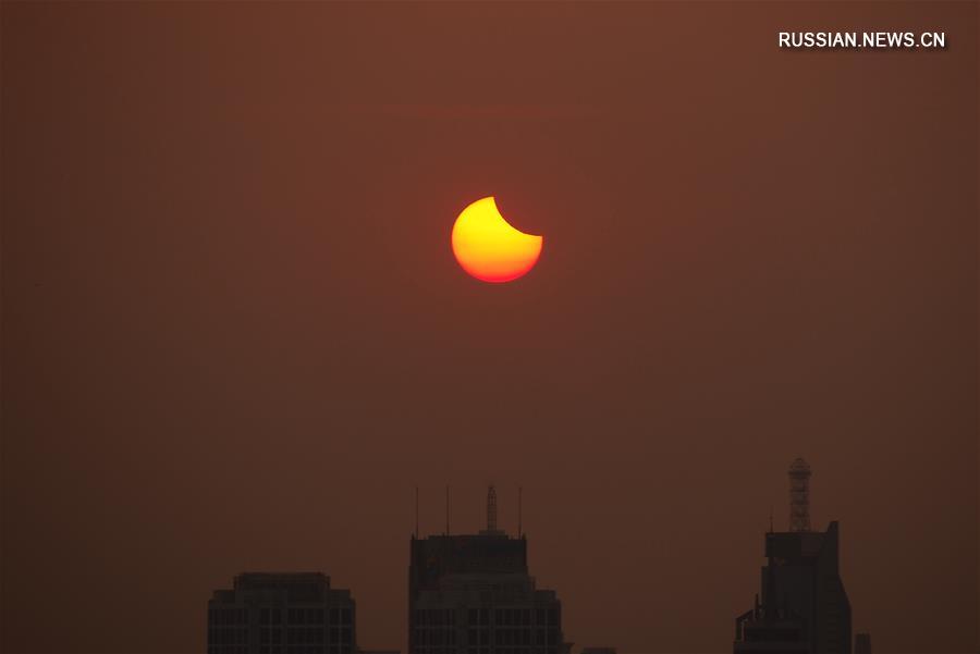 Частное солнечное затмение в небе над Китаем