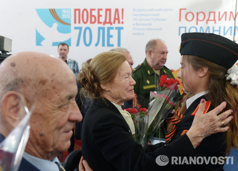 Курсантка военного училища дарит цветы ветеранам во время 