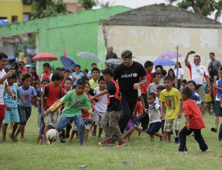 Дэвид Бекхэм играет в футбол с детьми во время своего визита на Филиппины