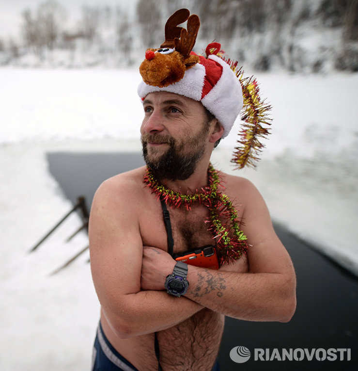 Участник клубов закаливания и зимнего плавания во время купания в проруби в Новосибирске