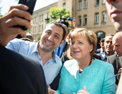 Меркель фотографировалась с приехавшими в Германию беженцами