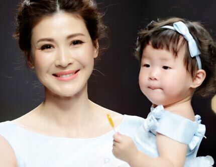 Китайская актриса Тун Лэй с дочкой в свадебных платьях на Неделе моды в Шанхае