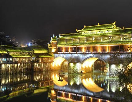 Древний город Фэнхуан горит красочными огнями