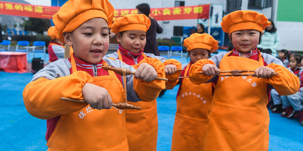 Воспитанники детского сада учатся делать китайские сладости из солодового сахара