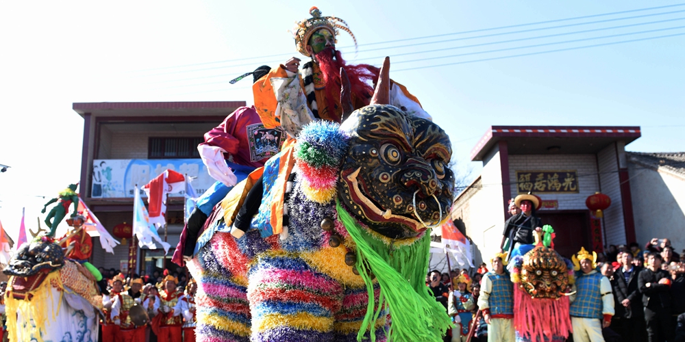 Праздничное шествие на ходулях в костюмах зверей в поселке Цинхэ
