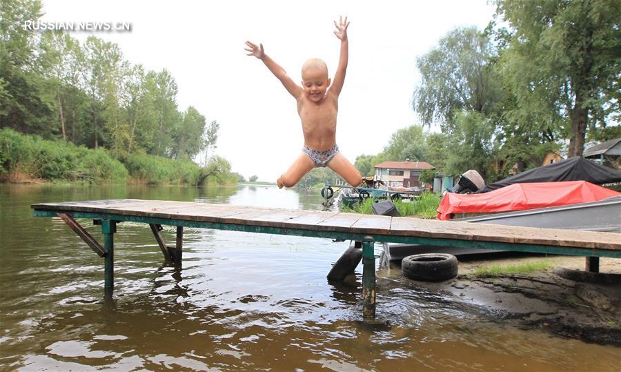 Жители Беларуси спасаются от жары, купаясь в Днепре
