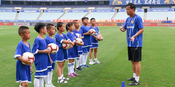 В летние каникулы китайские школьники наслаждаются футбольным спортом